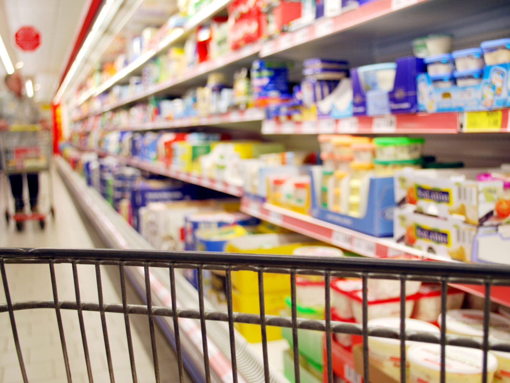 blurred shopping people with supermarket cooling shelf